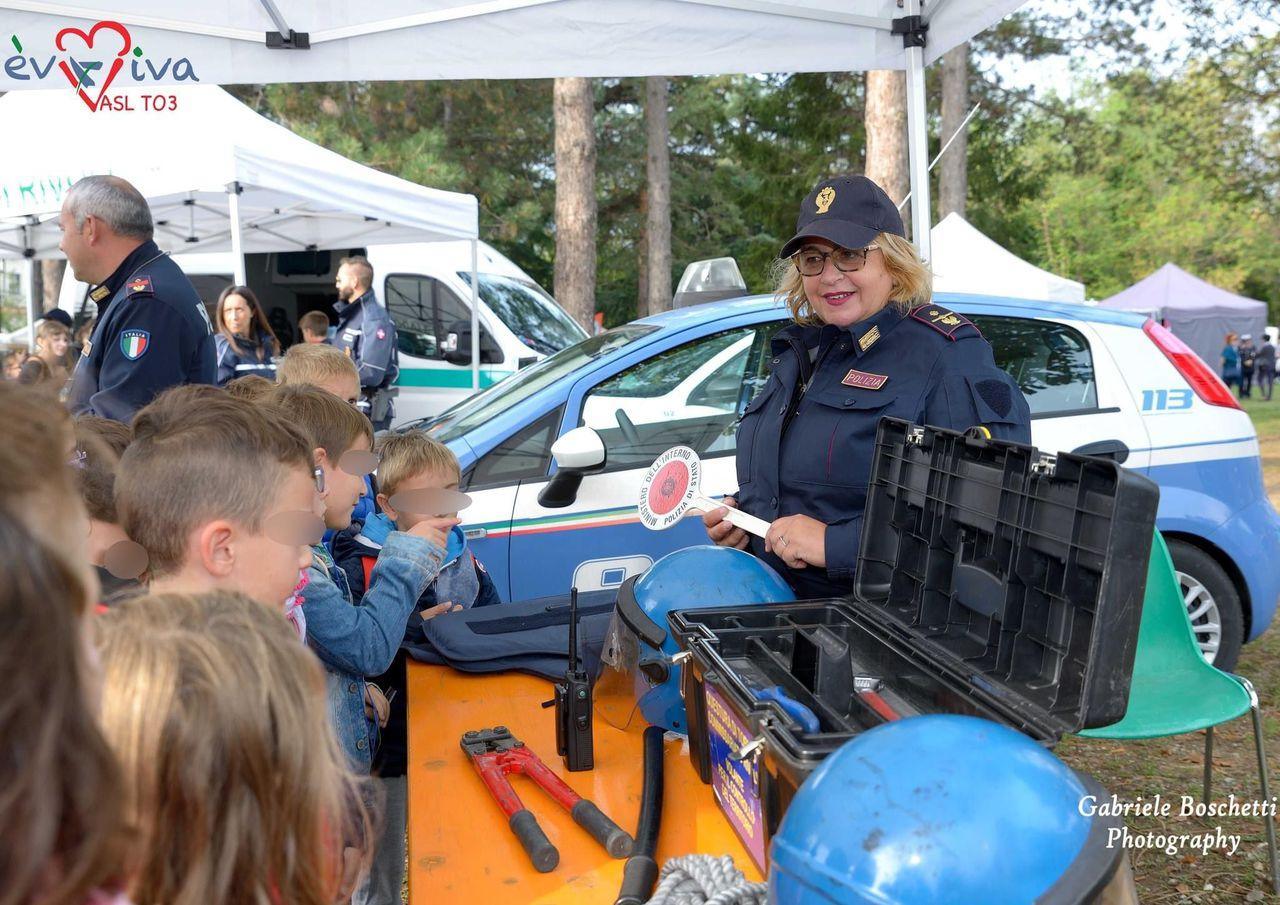 Police officers showing vehicles and equipment to a group of children