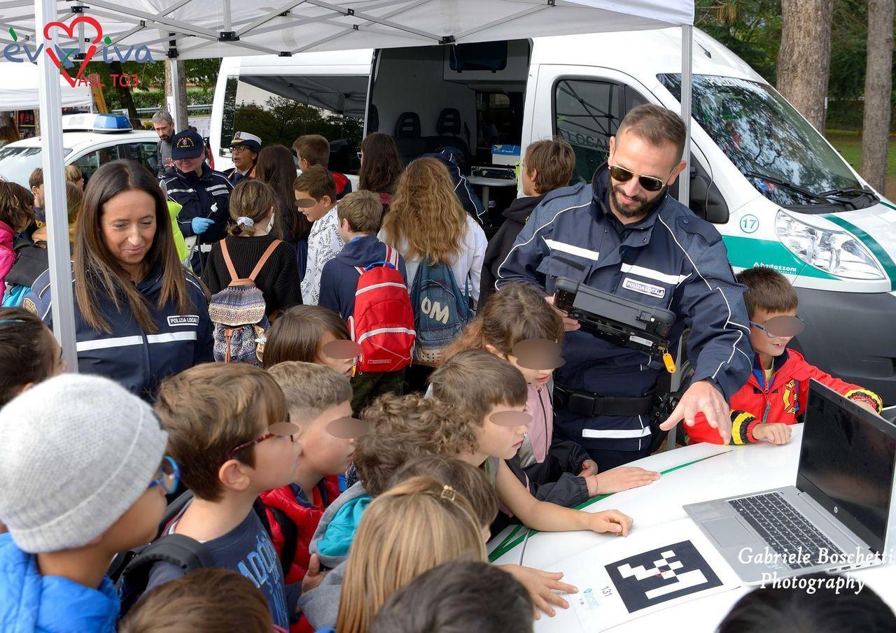Local Police officer showing an electronic device to a group of schoolchildren